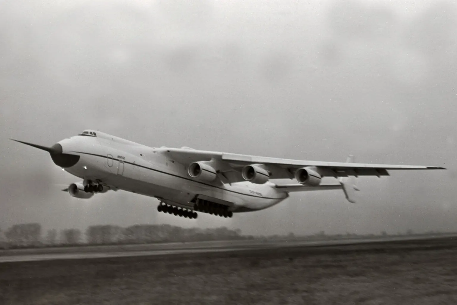 The Antonov An-225 Mriya prototype taking off in December 1988, six engines and a twin tail, in a black-and-white photograph.
