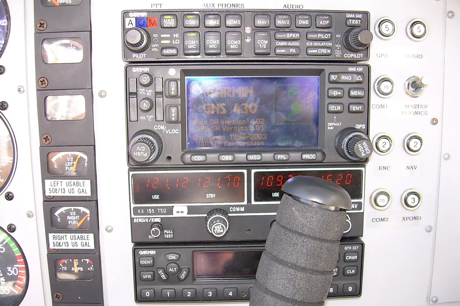 The radio and navigation stack of a light aircraft, with a GPS screen and frequency displays.