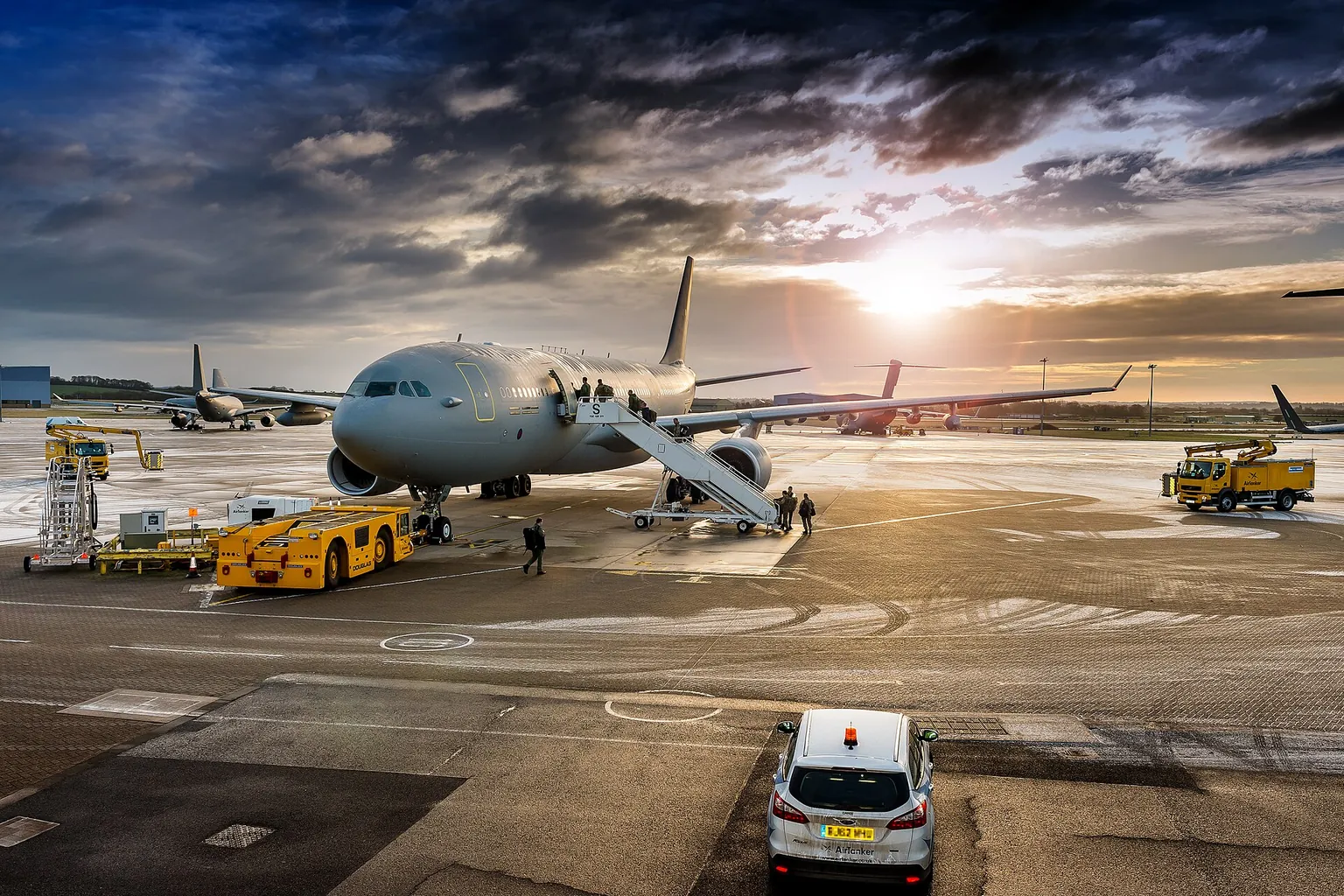 An RAF Voyager of 10 Squadron on the apron under a dramatic evening sky, boarding steps at its door and ground vehicles around it.