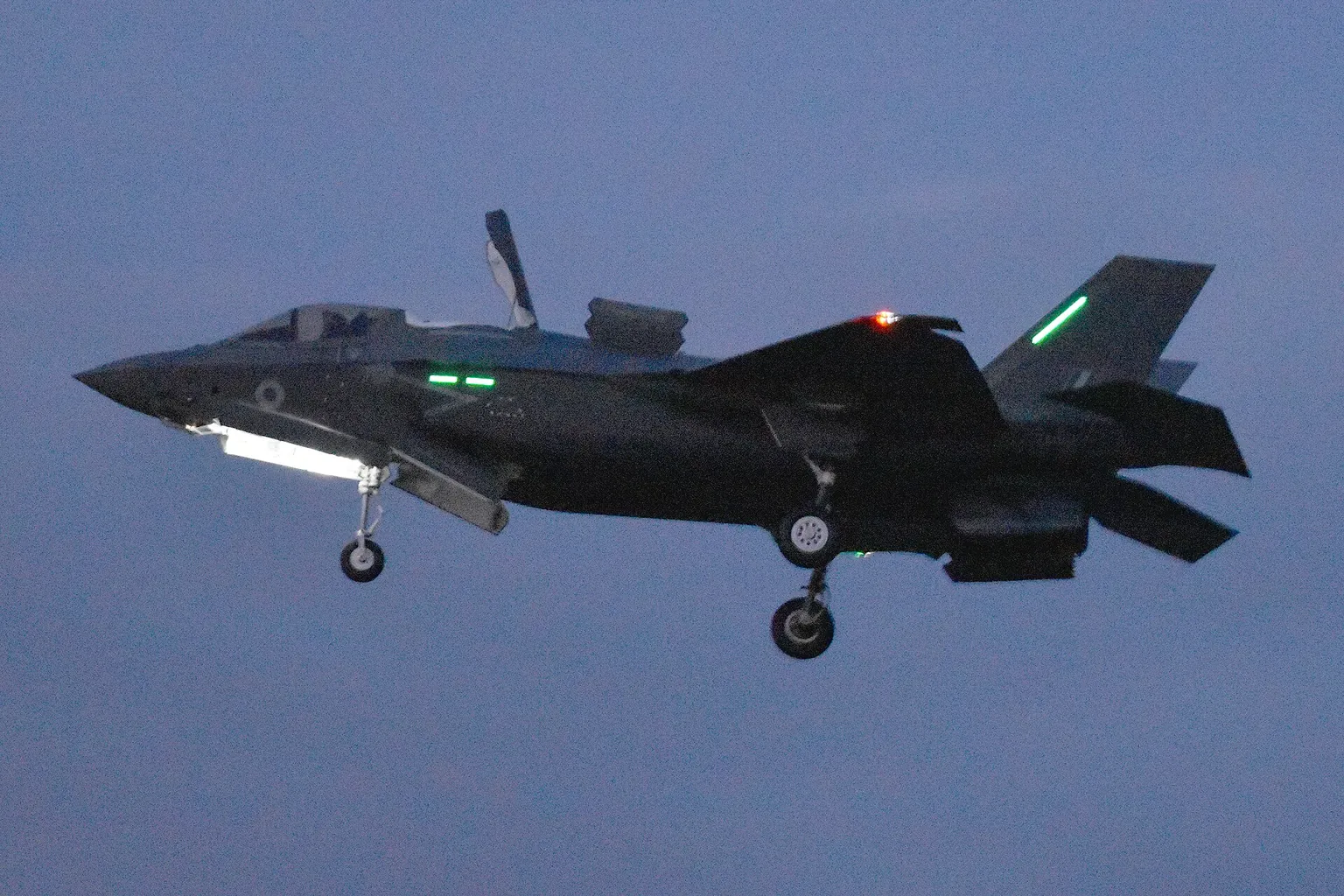 An RAF F-35B Lightning hovering with its lift doors open at dusk, arriving at RAF Marham in August 2018.