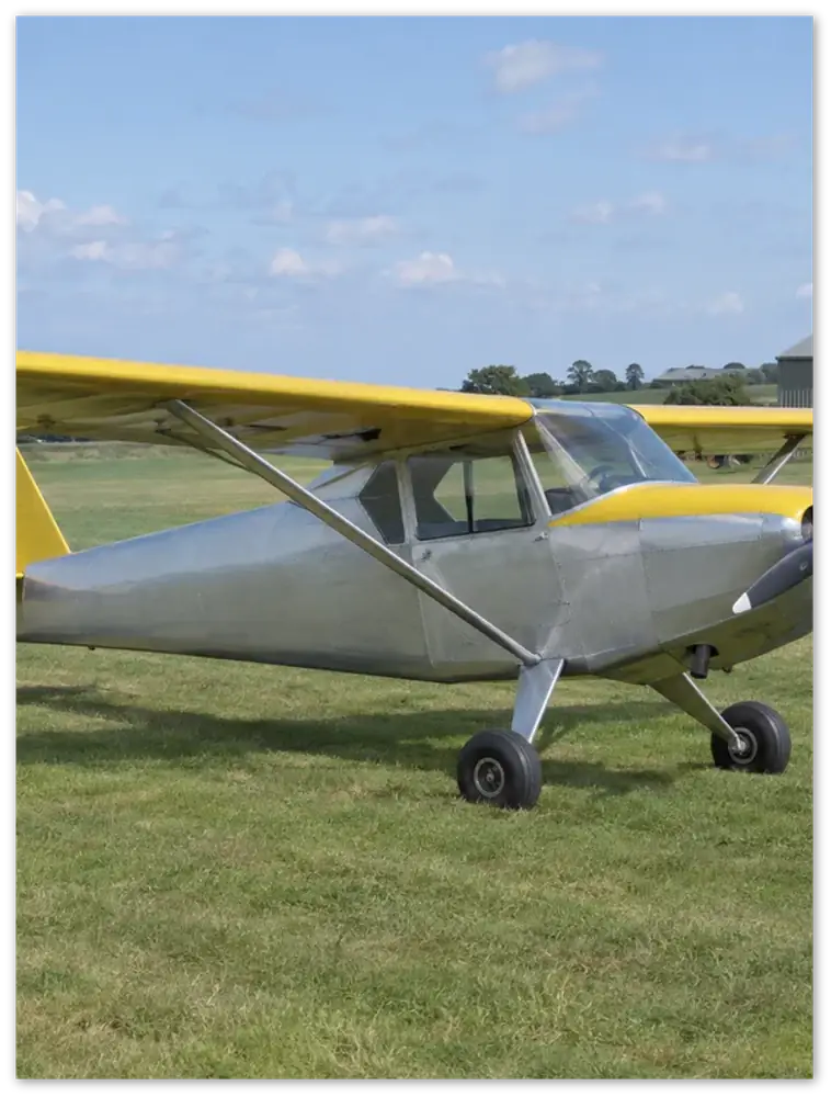 Gelato product render: an example photo of a silver and yellow light aircraft on grass, printed edge to edge on a frameless metal panel