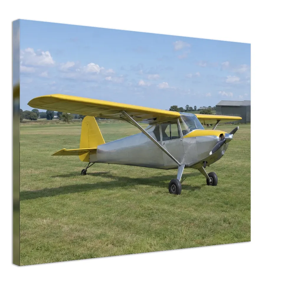 Example render of a stretched canvas: a silver and yellow light aircraft parked on grass across the front, a soft blurred band of the picture’s colours on the sides