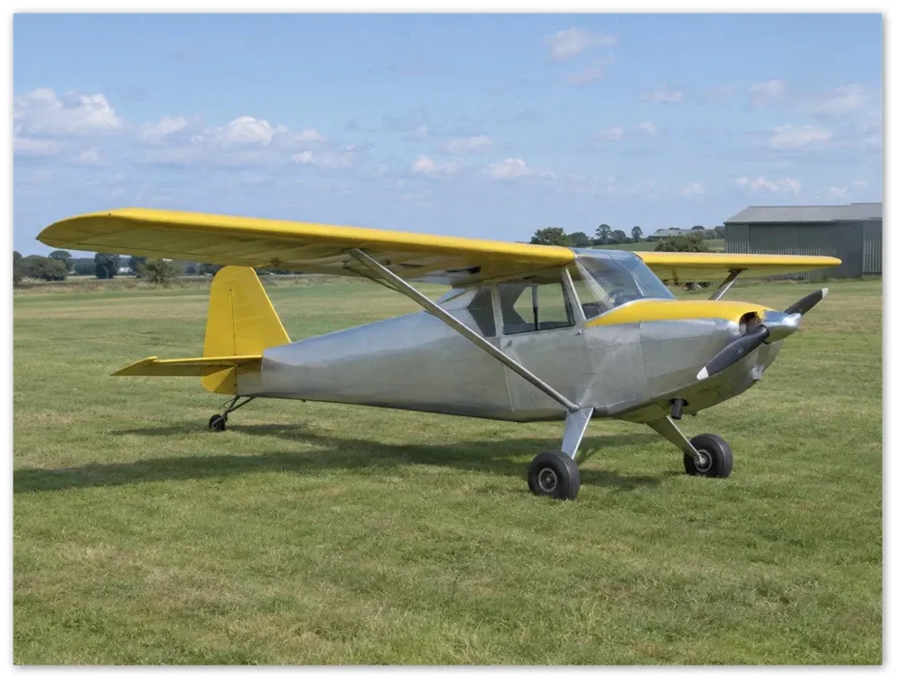 Example render of a frameless metal print: a silver and yellow light aircraft parked on grass