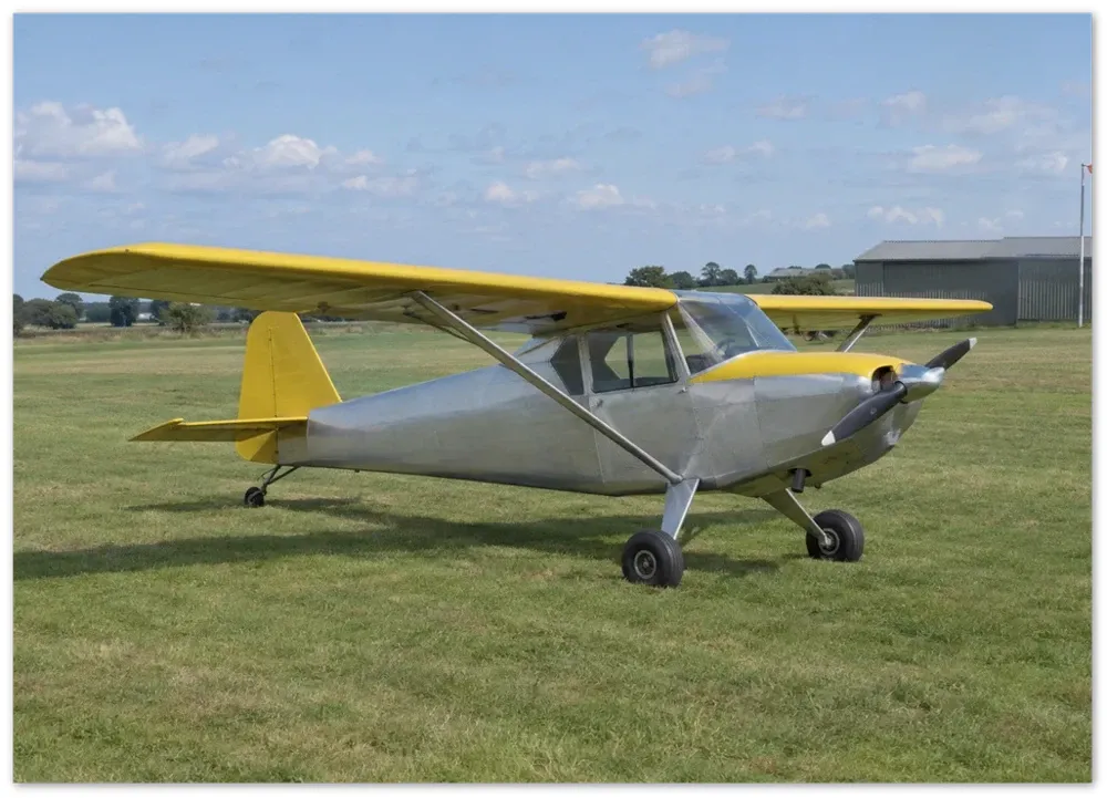 Example render of an unframed paper poster: a silver and yellow light aircraft parked on grass